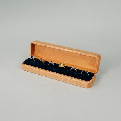Open Jewellery Box made of beech wood while the interior of the box is lined with soft velvet with six rings placed inside.